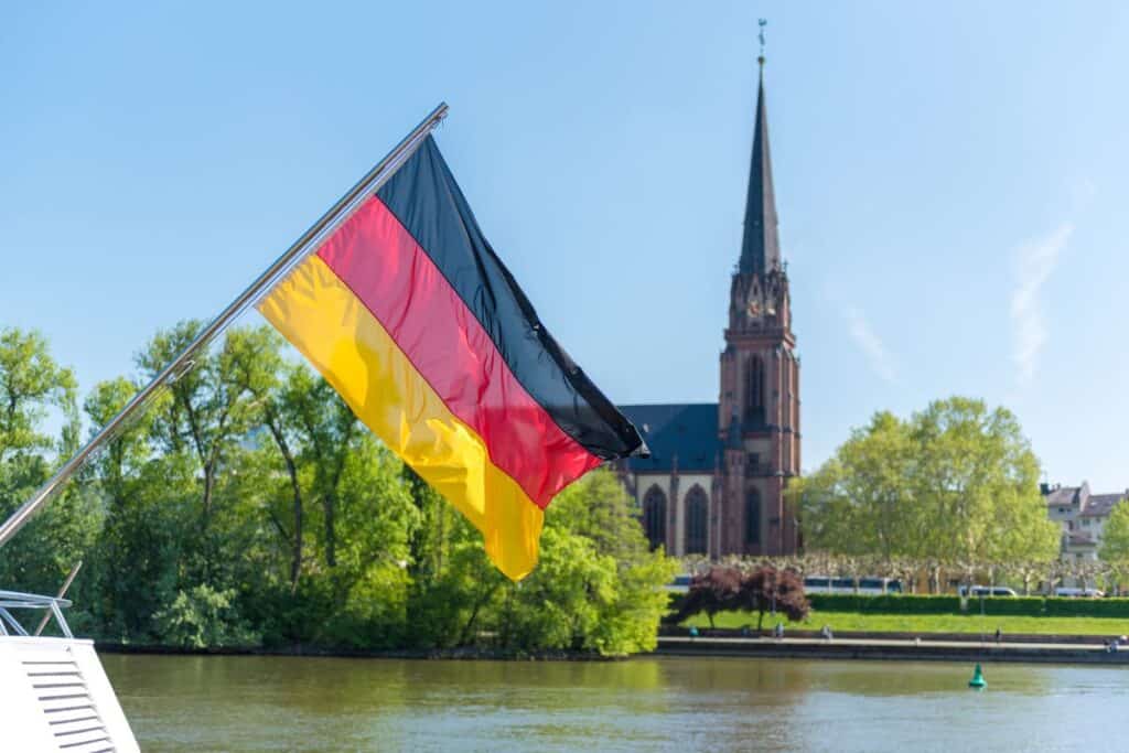 Tyskflagga, flod och kyrka i bakgrunden