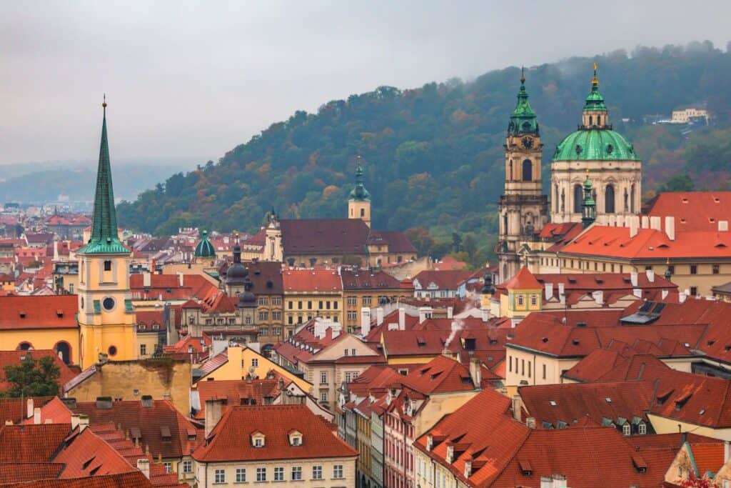 Bild över hustaken och kyrktornen i Malá Strana, Prag, som ger en pittoresk vy över stadsdelen.